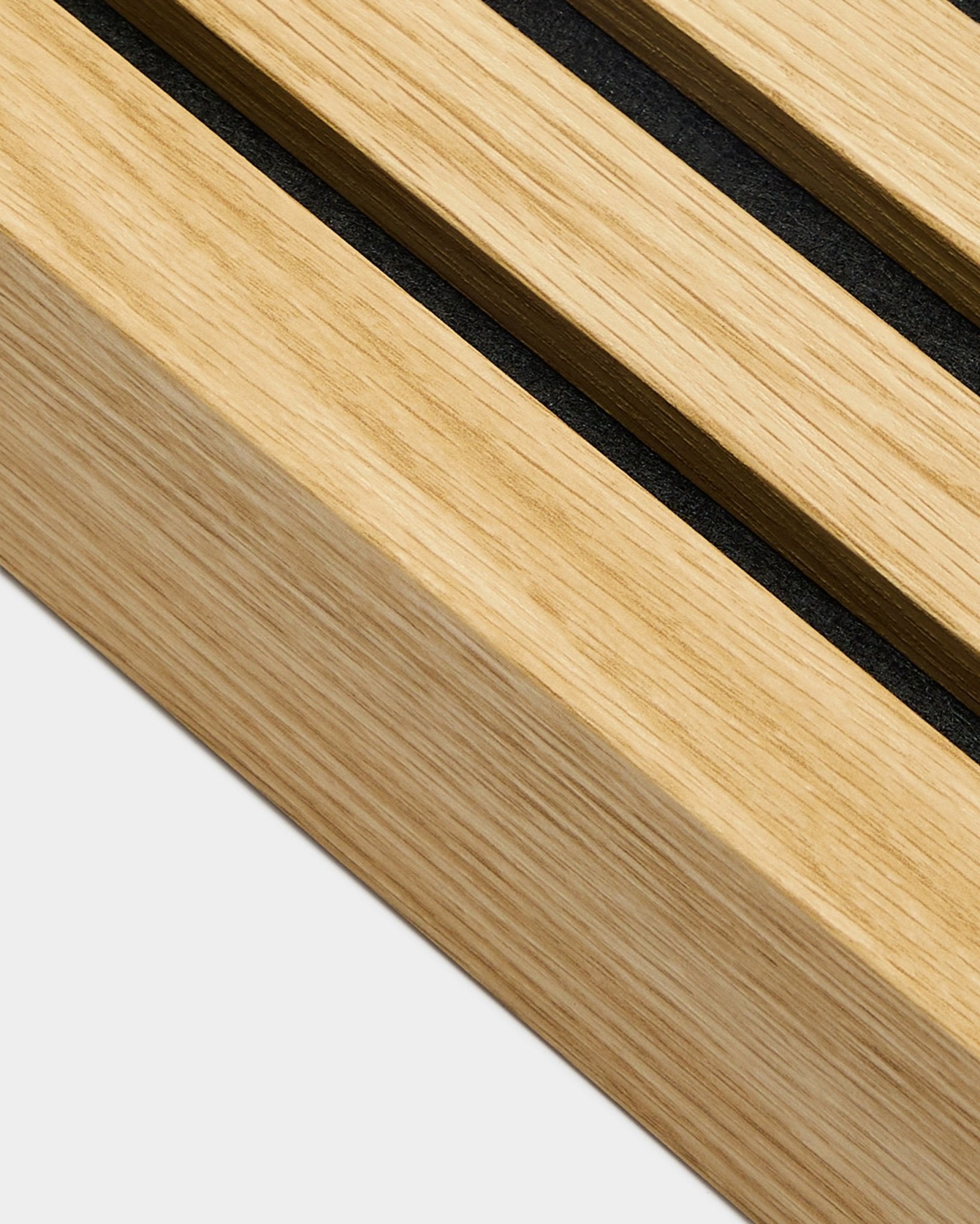 Close-up of WoodUpp Akupanel installation product, end lamella in Southern Oak, 6.7cm wide, featuring black grooves on light wood for defined acoustic panel lines.